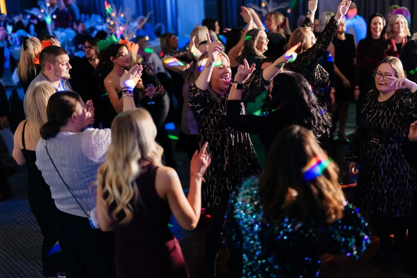 A group of friends dancing on a dimly lit dancefloor