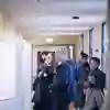 Several people examine posters on display in a corridor in Canham Turner