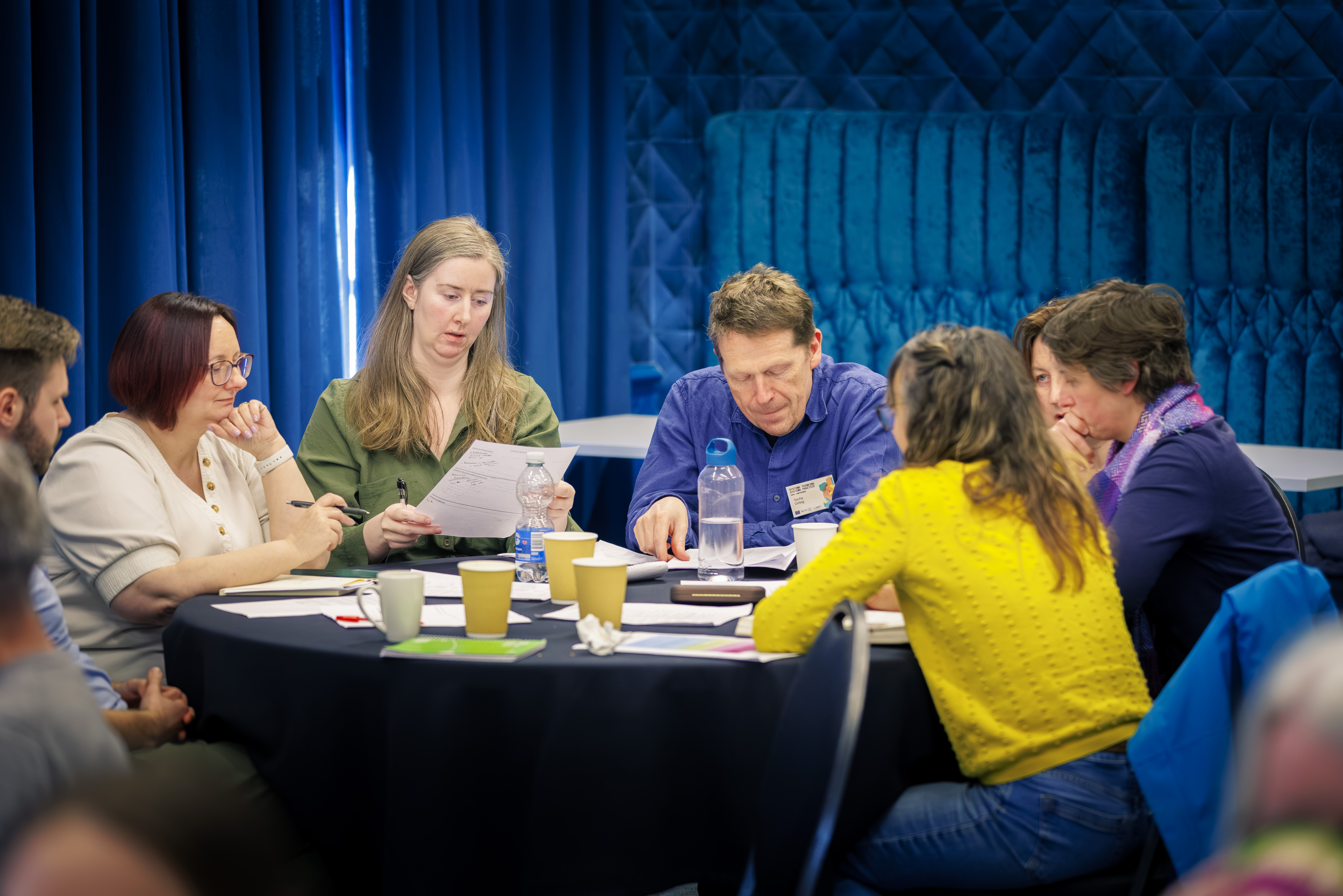 A table of people take part in a group activity in a modern events space