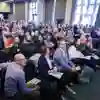 A large crowd of attendees sitting in rows at a conference