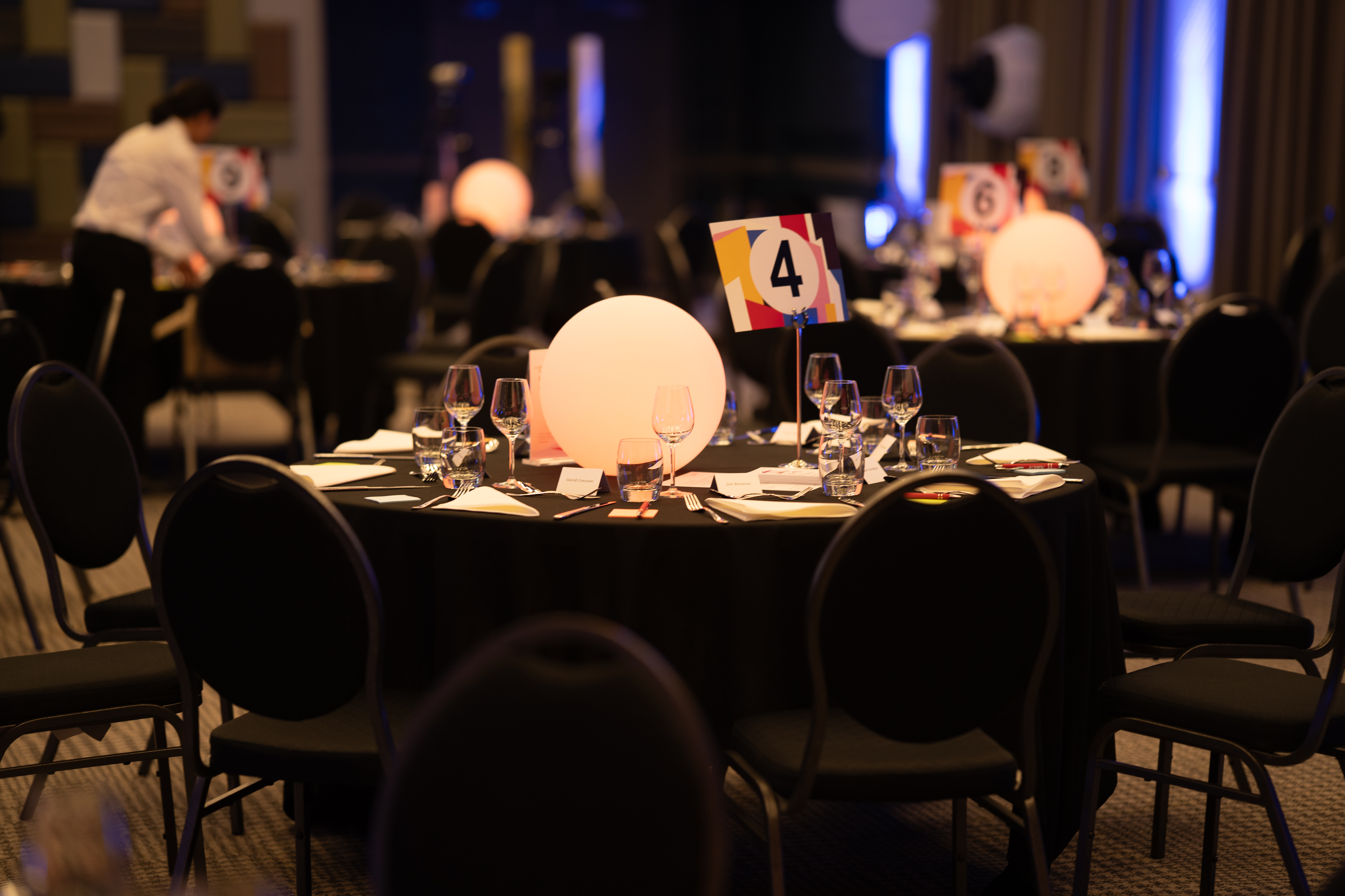 A close up of a set table with a large spherical glowing light in the middle