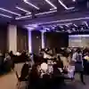 Business representatives sit at round tables for a meal as part of a conference function