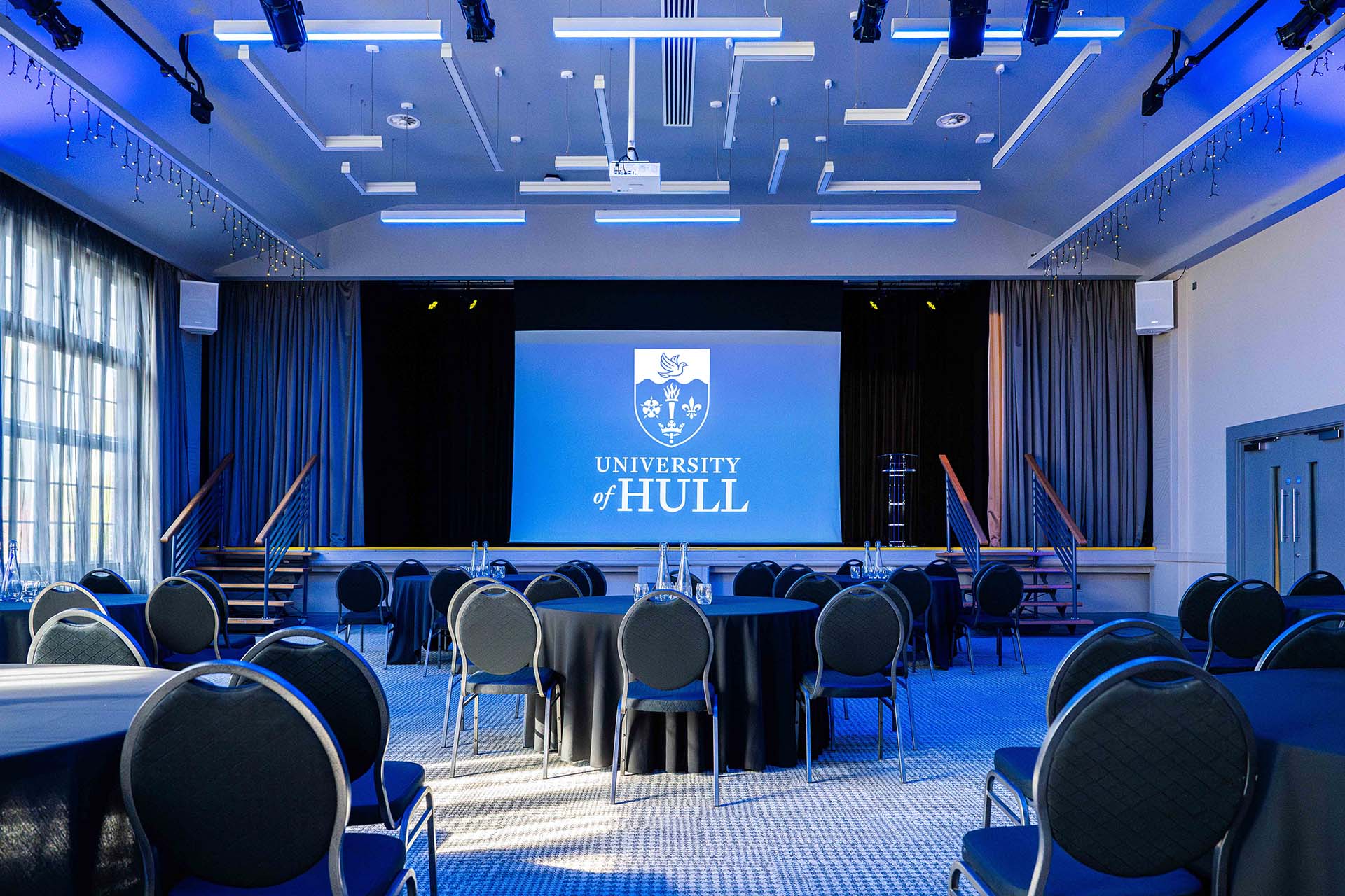 Tables and a projector screen set up in Kinglsey Suite