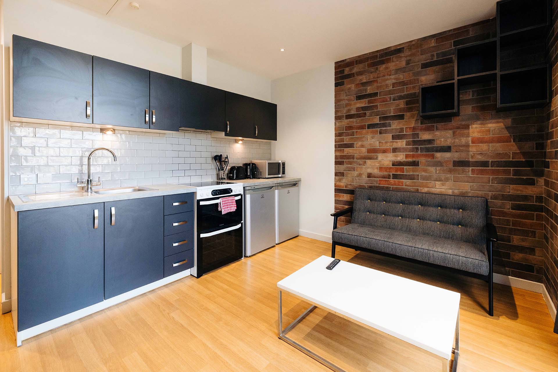 Rooftop flat living area at The Courtyard with a sofa and kitchen area.