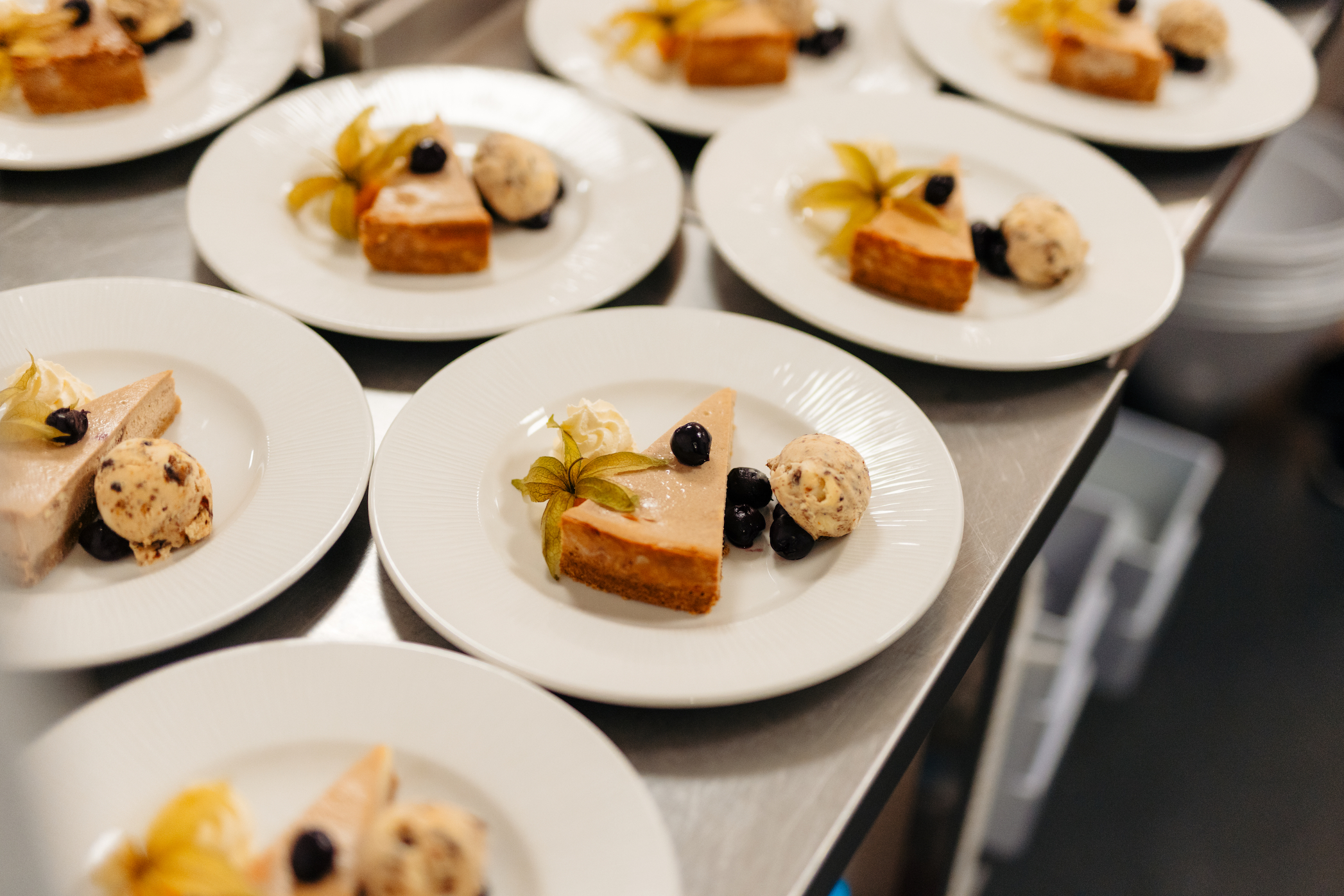 Rows of a cheesecake dessert with ice cream and berries