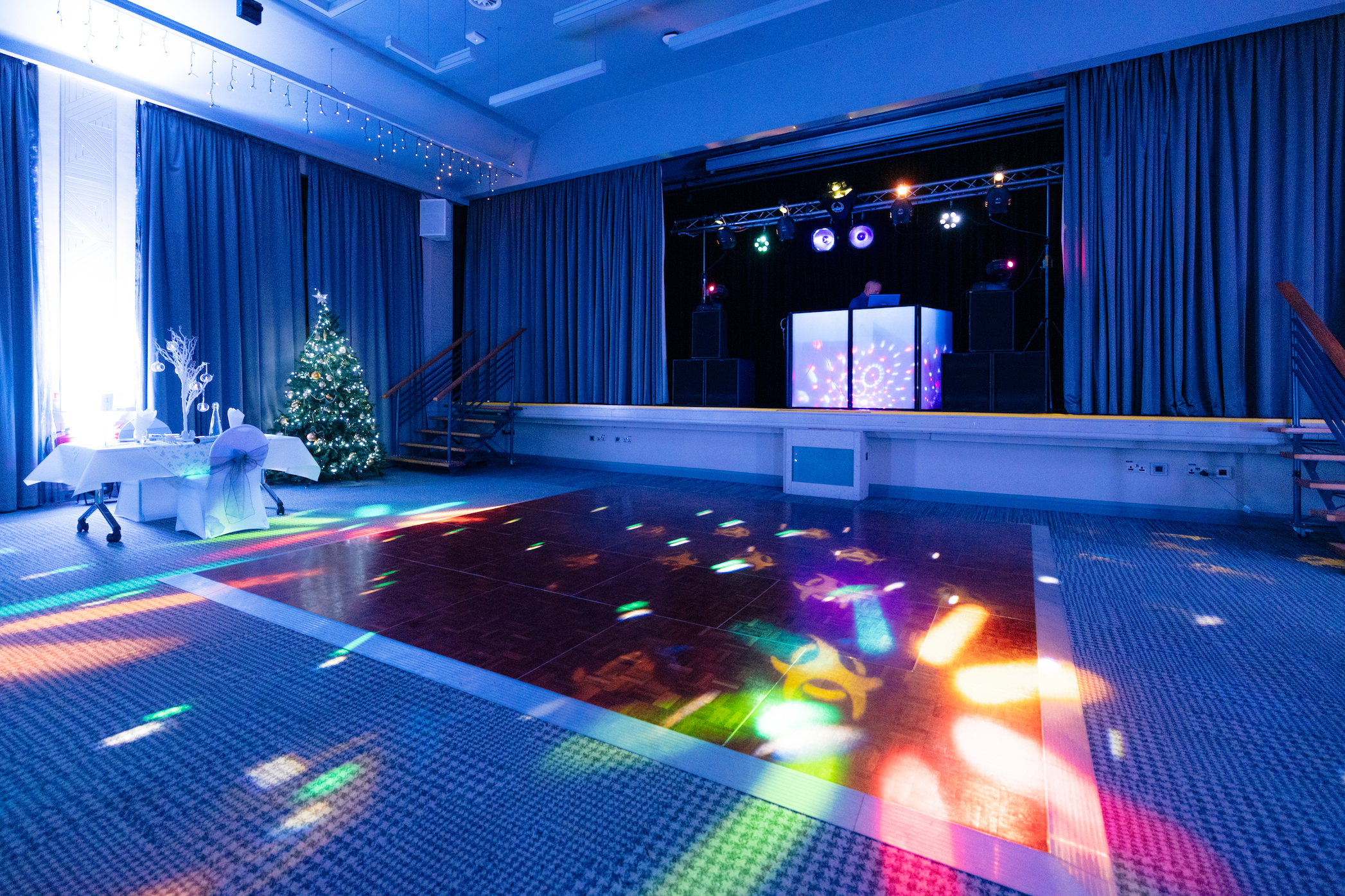 Brightly coloured party lights beam down on to a large dancefloor in the Kingsley Suite