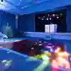 Brightly coloured party lights beam down on to a large dancefloor in the Kingsley Suite