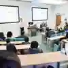A man gives a talk in a small lecture theatre to a group of students